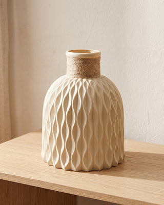 A beige rope neck vase, empty, on a pale oak console
