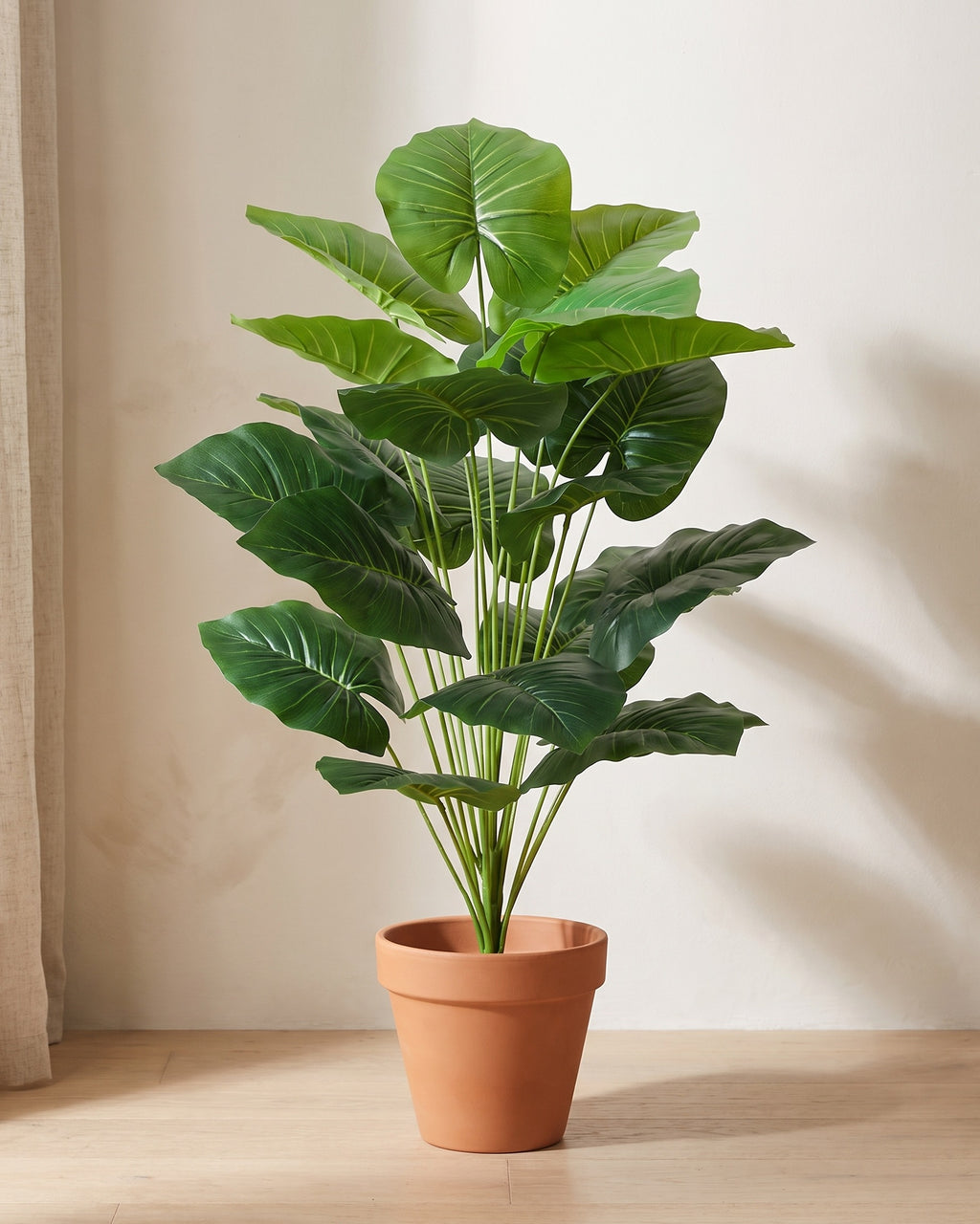 Artificial elephant ear plant, 39.4 in tall with 18 leaves, standing in a plain terracotta pot on a pale oak floor (pot not included).