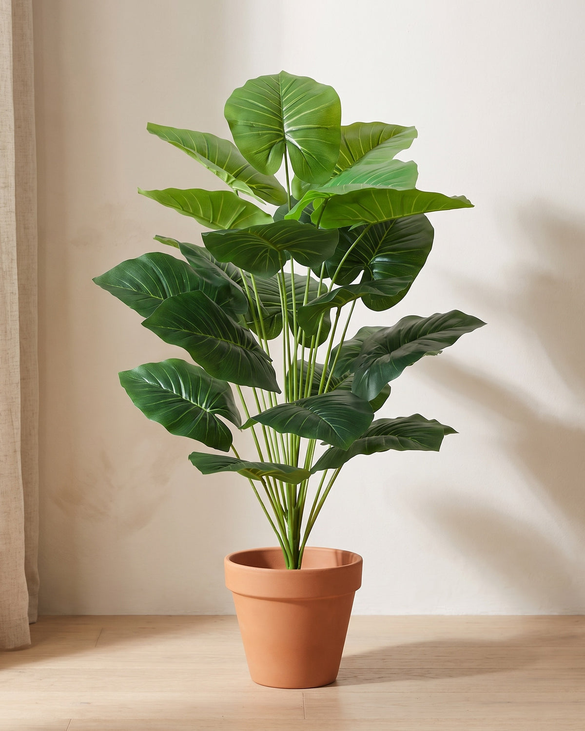 Artificial elephant ear plant, 39.4 in tall with 18 leaves, standing in a plain terracotta pot on a pale oak floor (pot not included).