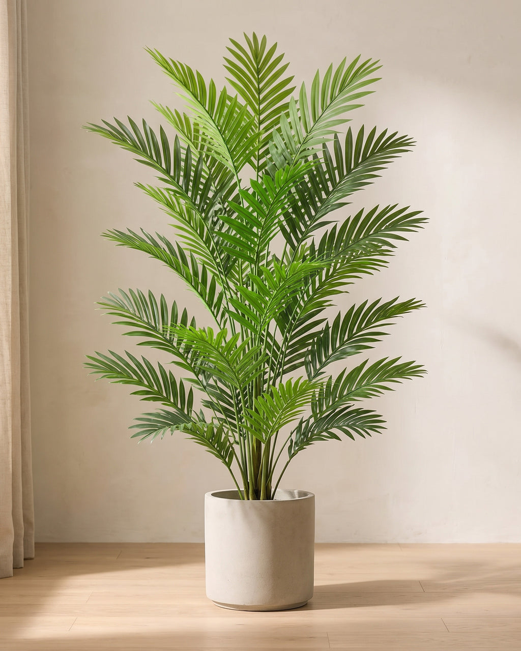 Artificial areca palm in a plain stone pot on an oak floor in soft daylight (pot not included)
