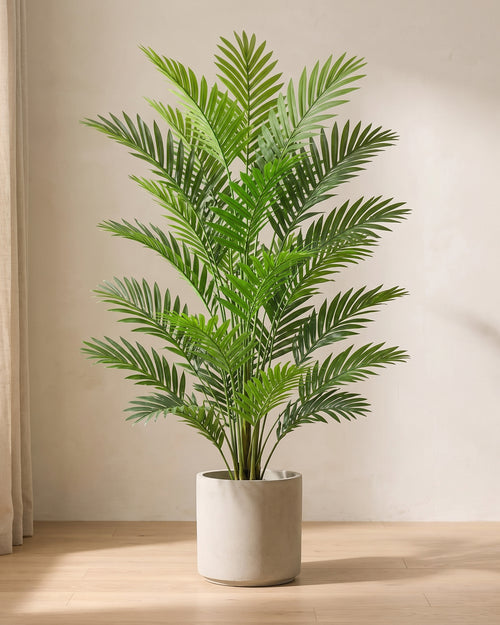 Artificial areca palm in a plain stone pot on an oak floor in soft daylight (pot not included)
