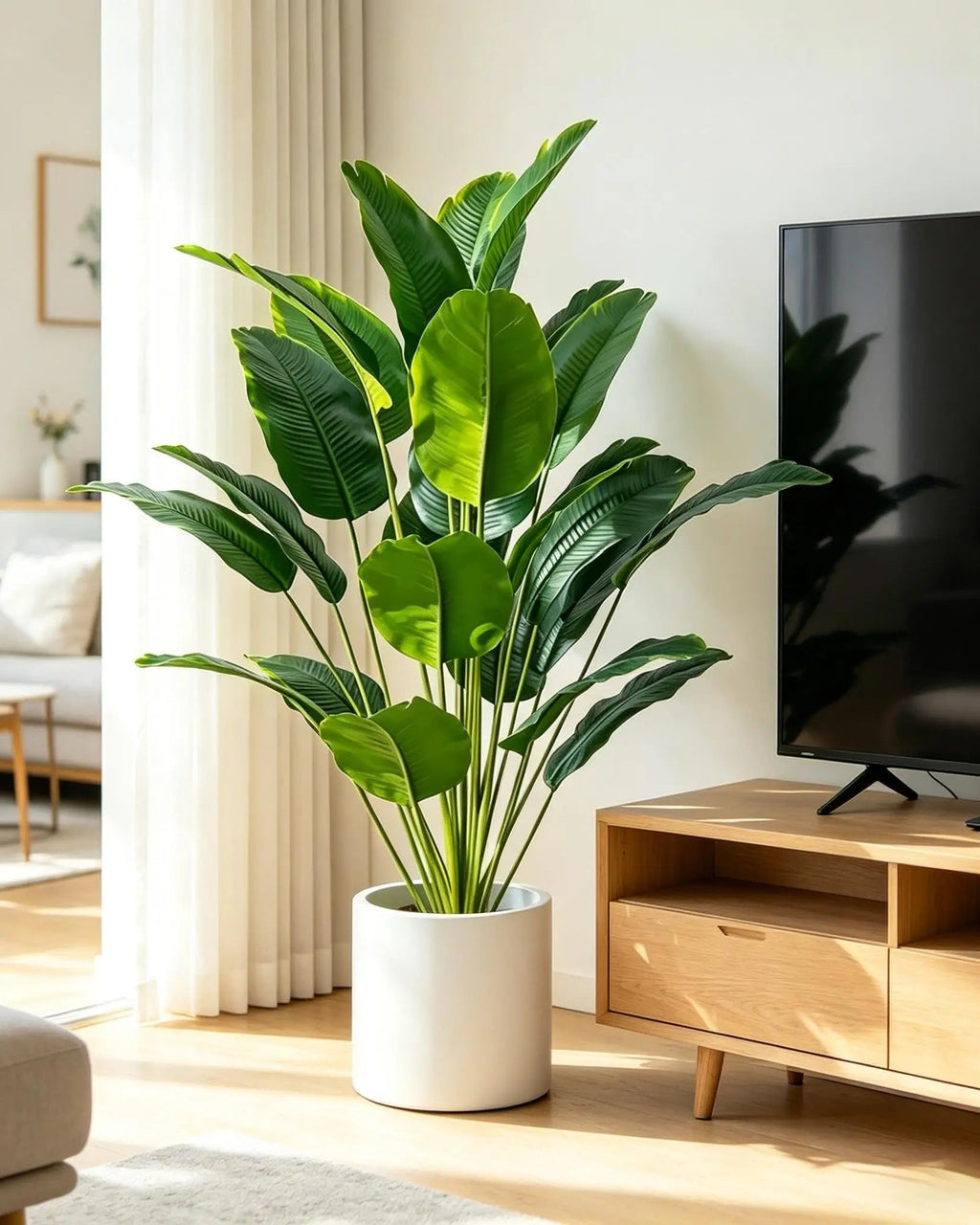 Artificial bird of paradise plant beside a wooden TV console in a living room