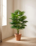 The artificial fan palm in the corner of a bare room, shown in a plain terracotta pot (pot not included).