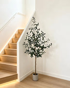 Artificial olive tree in a gray pot beside a staircase (planter not included)