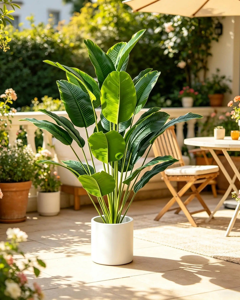 Artificial bird of paradise plant on a sunny terrace beside a garden table