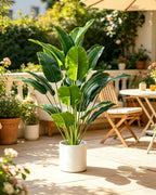 Artificial bird of paradise plant on a sunny terrace beside a garden table