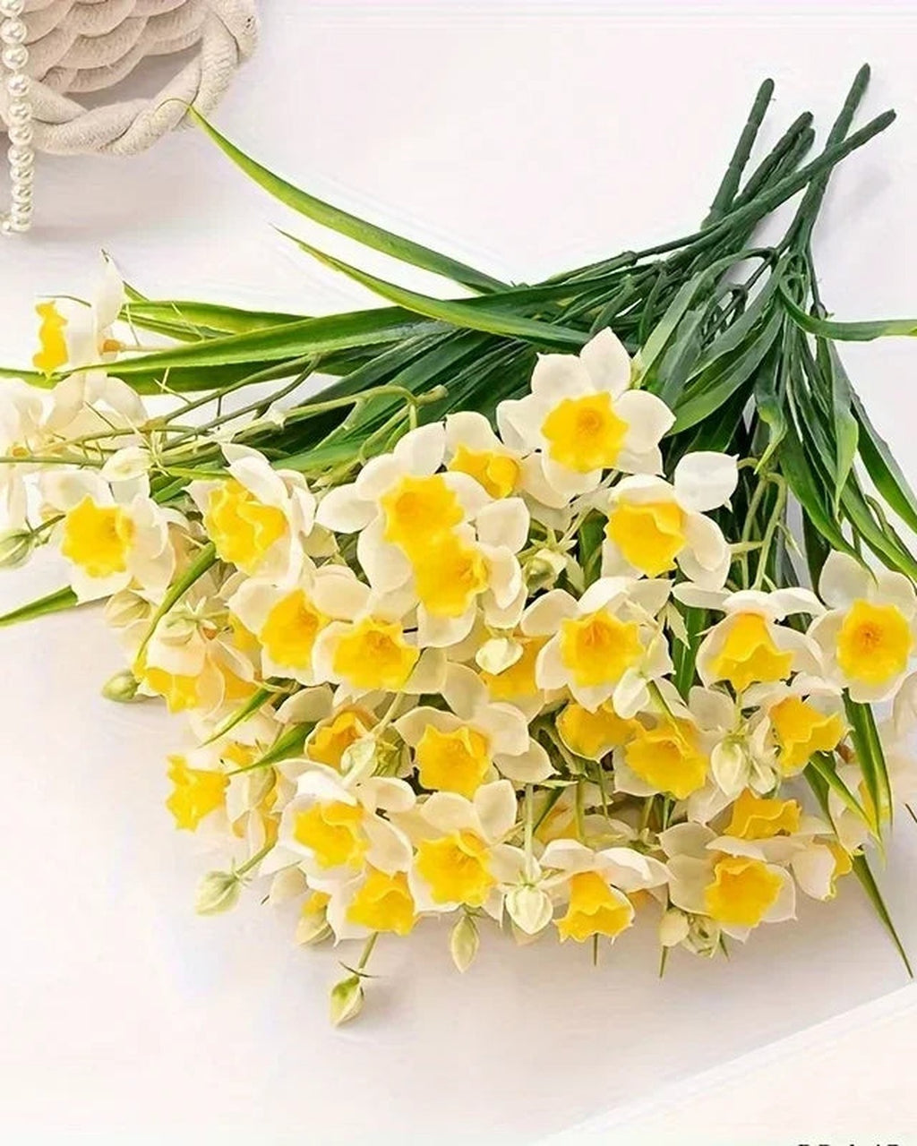 Close-up of the daffodil flowers and narrow green blades.