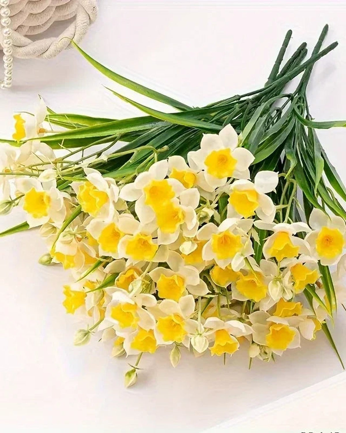 Close-up of the daffodil flowers and narrow green blades.