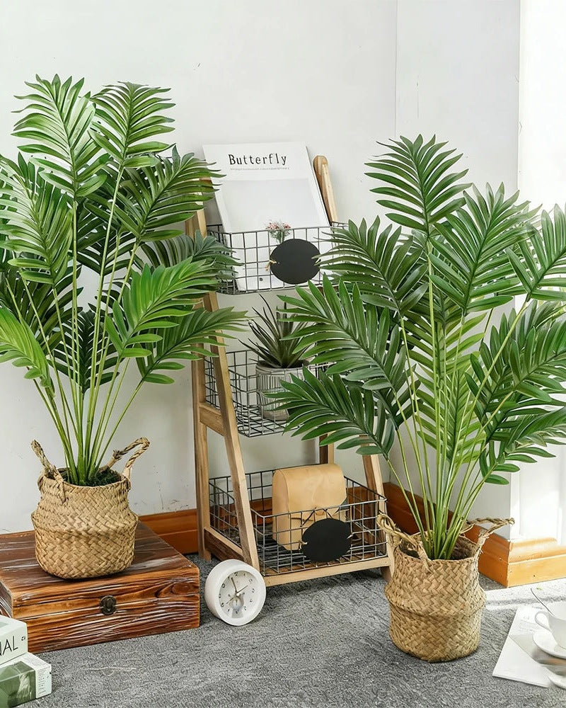 Two artificial areca palms in baskets beside a wooden shelving unit