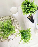 Mini artificial potted plants viewed from above on a woven mat