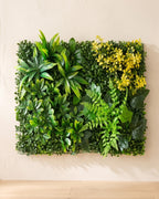 Green blades and yellow bloom artificial green wall panel fixed flat on an off-white plaster wall