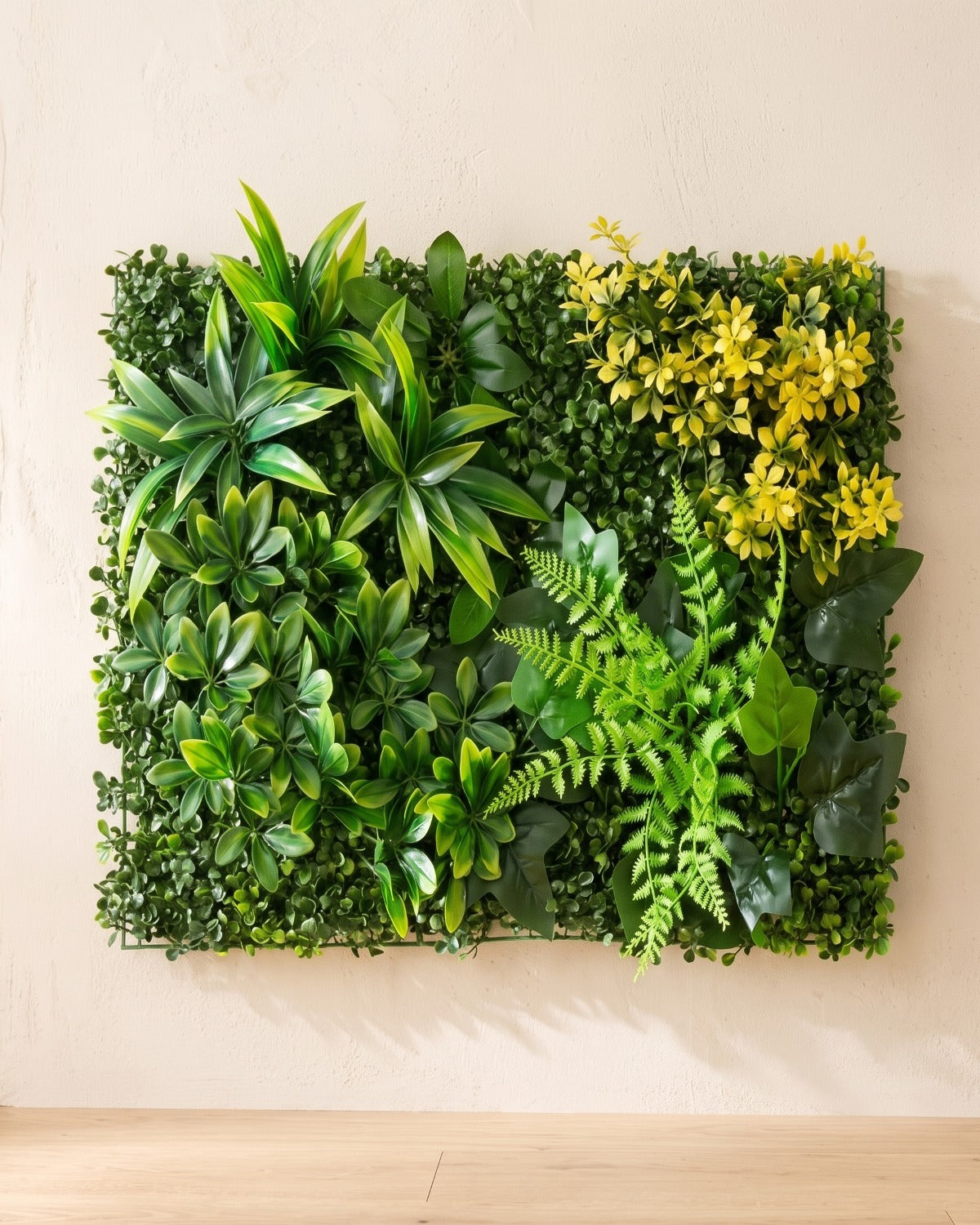 Green blades and yellow bloom artificial green wall panel fixed flat on an off-white plaster wall