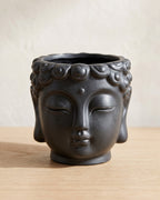 Charcoal Buddha head planter, empty on a pale oak table