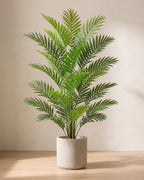 An artificial areca palm with eighteen fronds, in a plain stone pot on an oak floor; pot not included