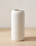 White striped cylinder vase, empty on a pale oak table
