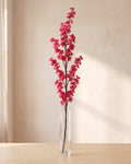 Rose Pink artificial peach blossom branch standing in a tall glass vase on a pale oak table; no vase is included