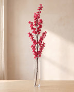 Rose Pink artificial peach blossom branch standing in a tall glass vase on a pale oak table; no vase is included