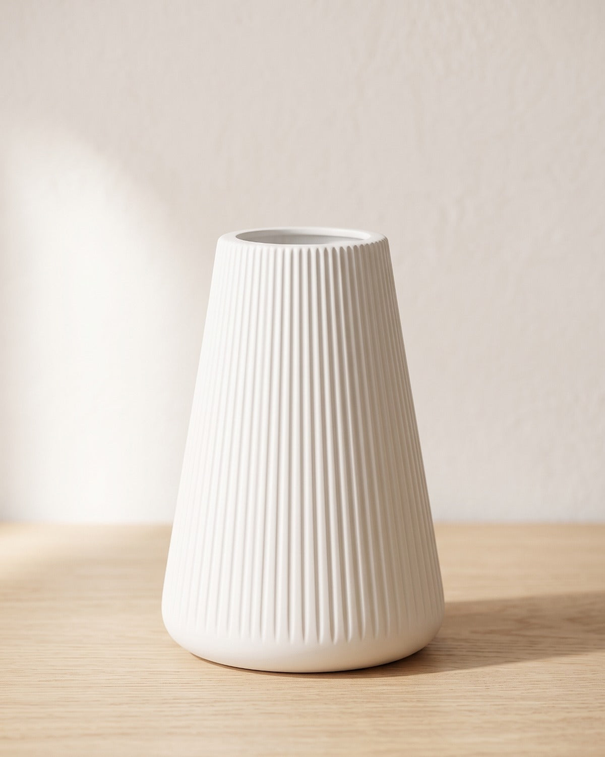 Fluted tapered vase, size S, empty on a pale oak table