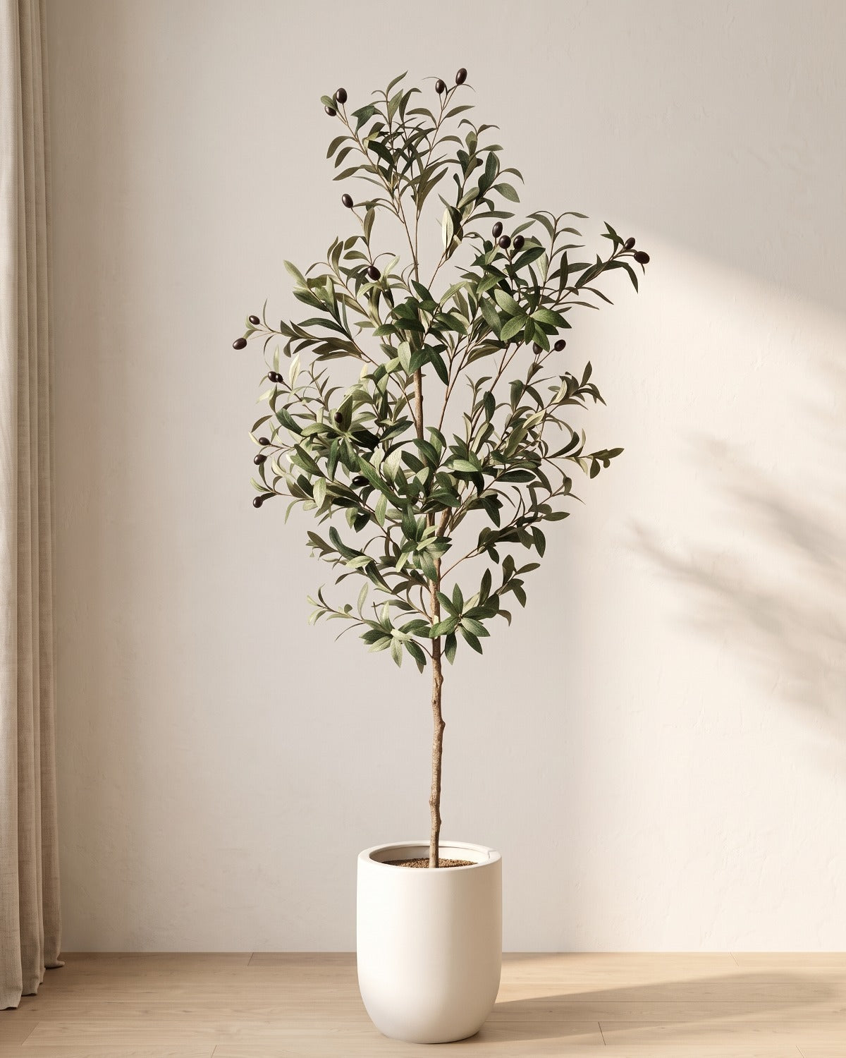 The 55 in artificial olive tree standing in a plain white pot on an oak floor; planter not included