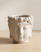 Stone Buddha head planter, empty on a pale oak table