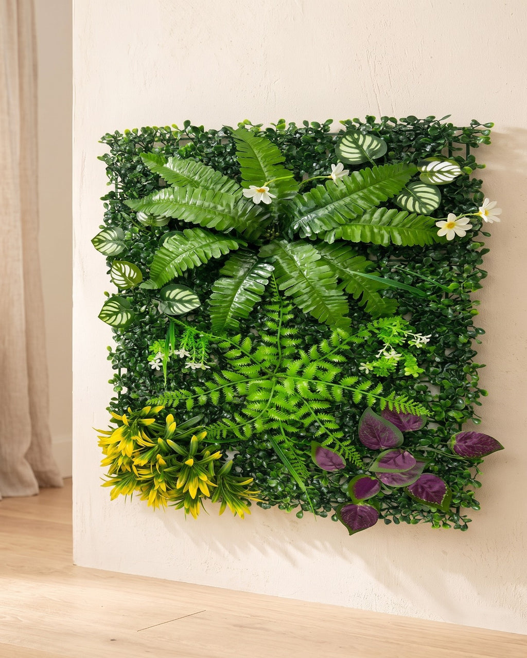 Fern, yellow bloom and purple artificial green wall panel fixed flat on an off-white plaster wall