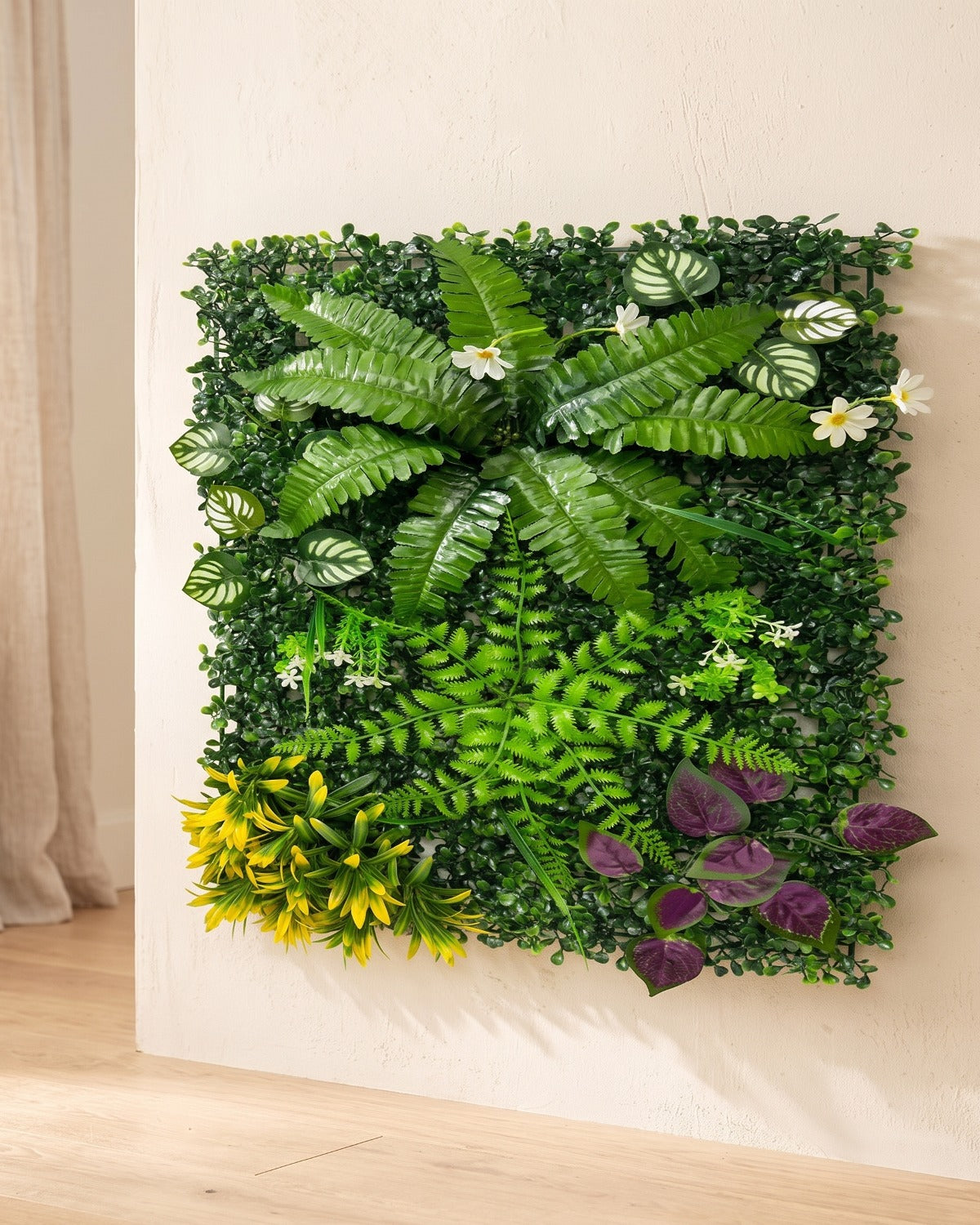 Fern, yellow bloom and purple artificial green wall panel fixed flat on an off-white plaster wall
