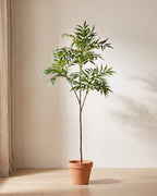 Artificial bamboo branch with three side branches standing in a plain terracotta pot on pale oak floorboards (pot not included).