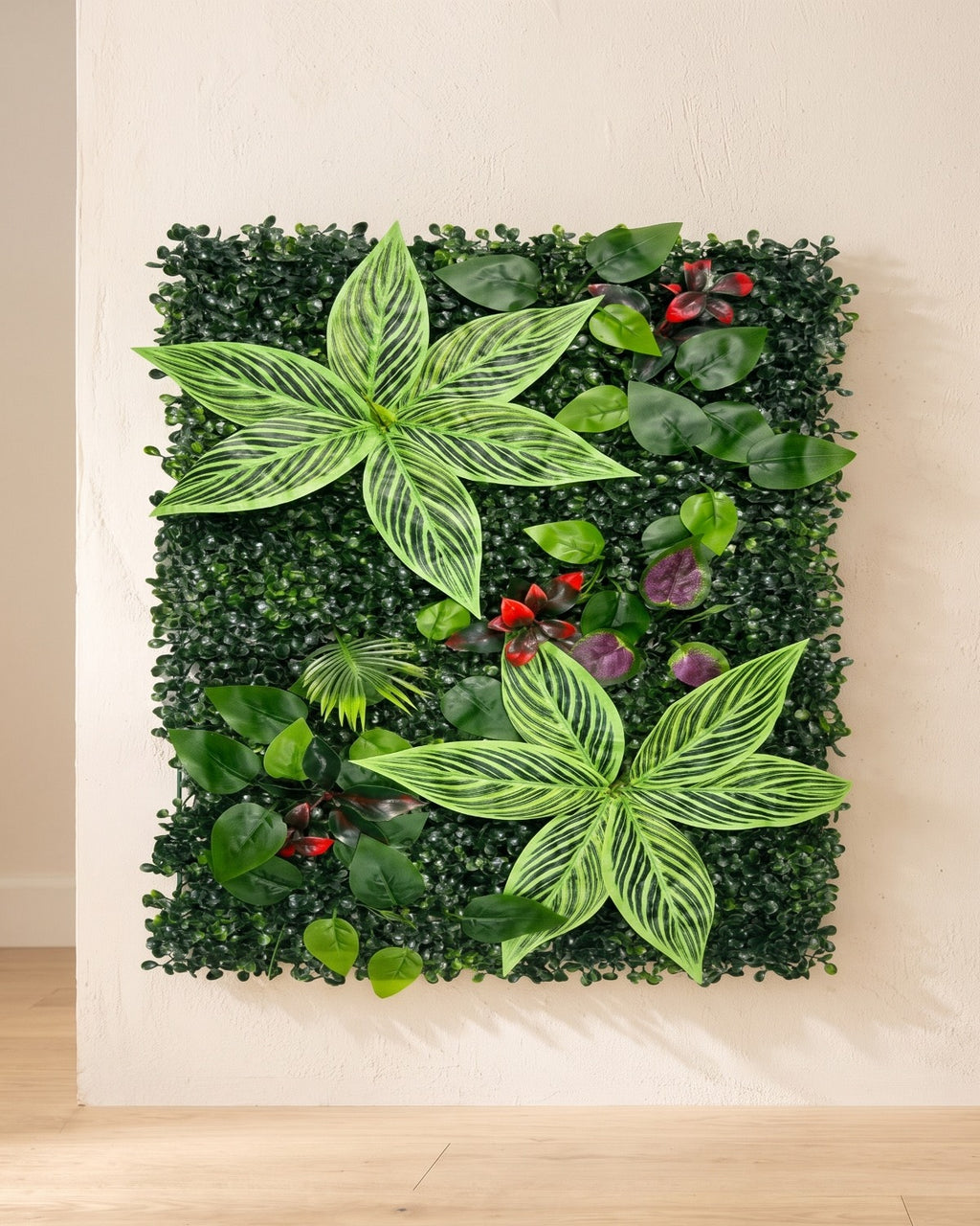 Variegated leaf and red berry artificial green wall panel fixed flat on an off-white plaster wall
