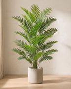 An artificial areca palm with twenty-four fronds, the fullest of the three, in a plain stone pot on an oak floor; pot not included