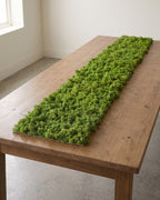 A long artificial moss runner lying down the length of a wooden table, the longest of the three sizes; table not included