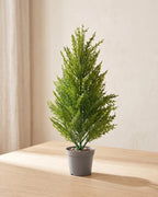 One artificial pine bundle standing in a plain nursery pot on a pale oak table; pot not included