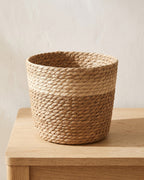 Woven seagrass plant basket, size L, empty on a pale oak table
