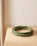 A small coil of green artificial jungle vine at its 3.3 ft length, on a pale oak table