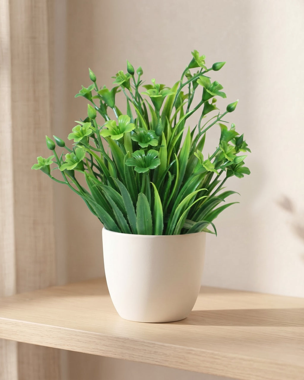 Clover style mini artificial potted plant in a plain white pot on a pale oak table