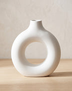 White donut vase, medium, empty on a pale oak table