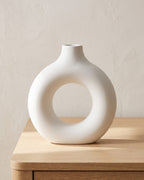 White donut vase, large, empty on a pale oak table