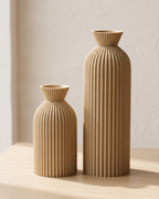 Khaki ribbed bottle vases, both sizes, empty on a pale oak table