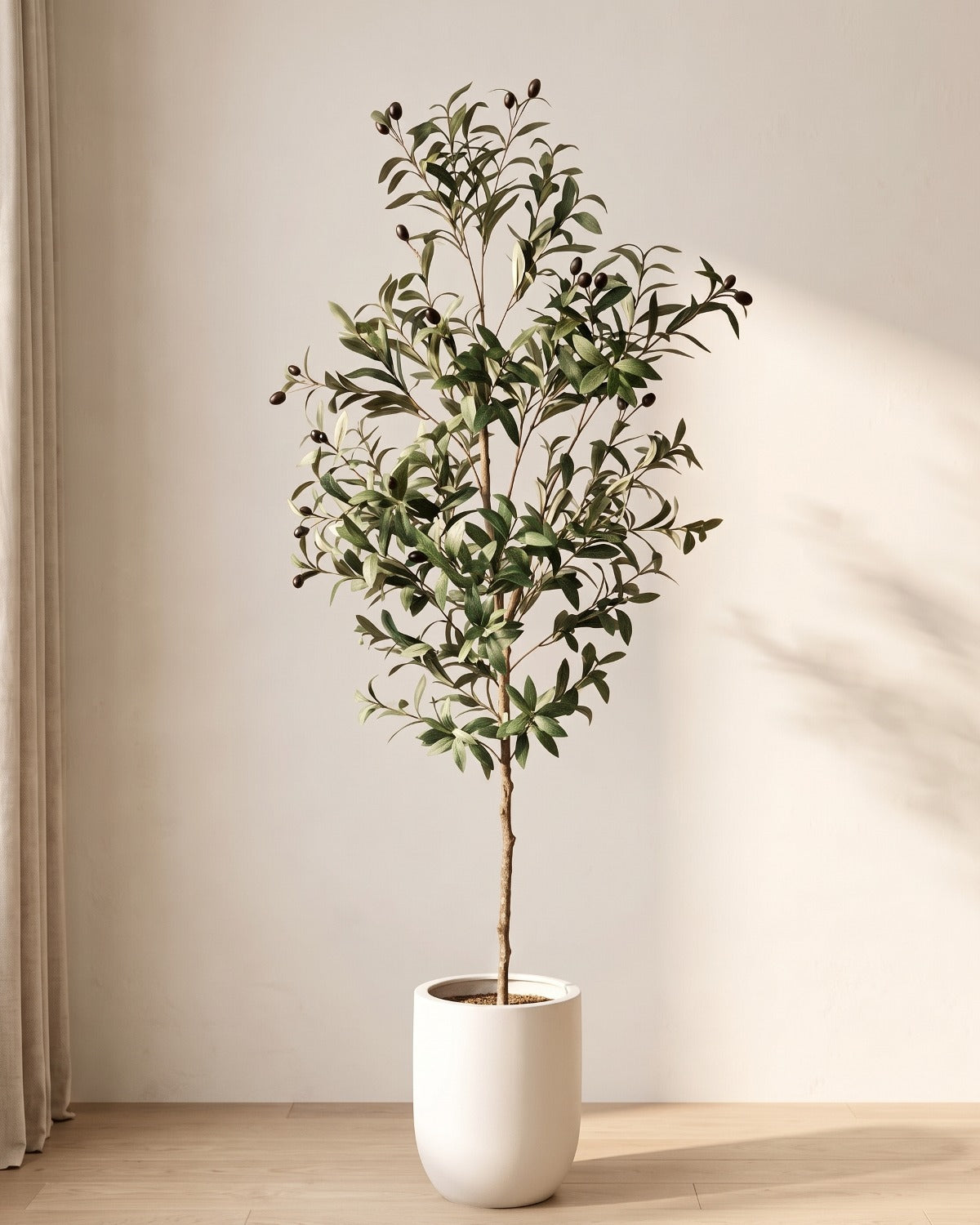 The 71 in artificial olive tree, the tallest of the set, standing in a plain white pot on an oak floor; planter not included