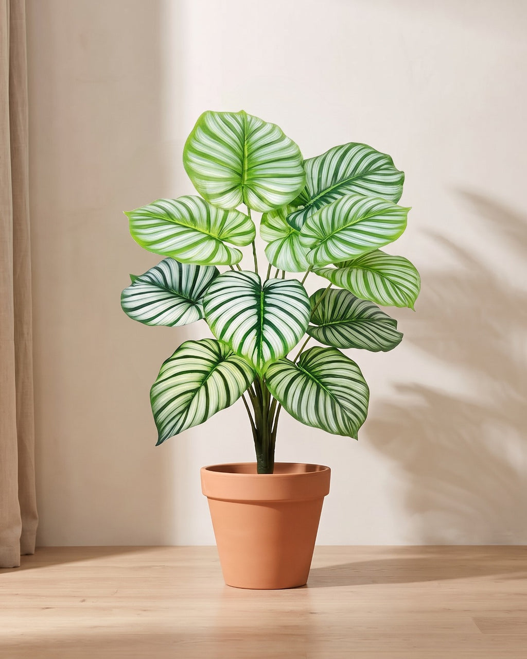 Artificial leaf bush with rounded leaves striped silver-white along every vein, in a plain terracotta pot; pot not included