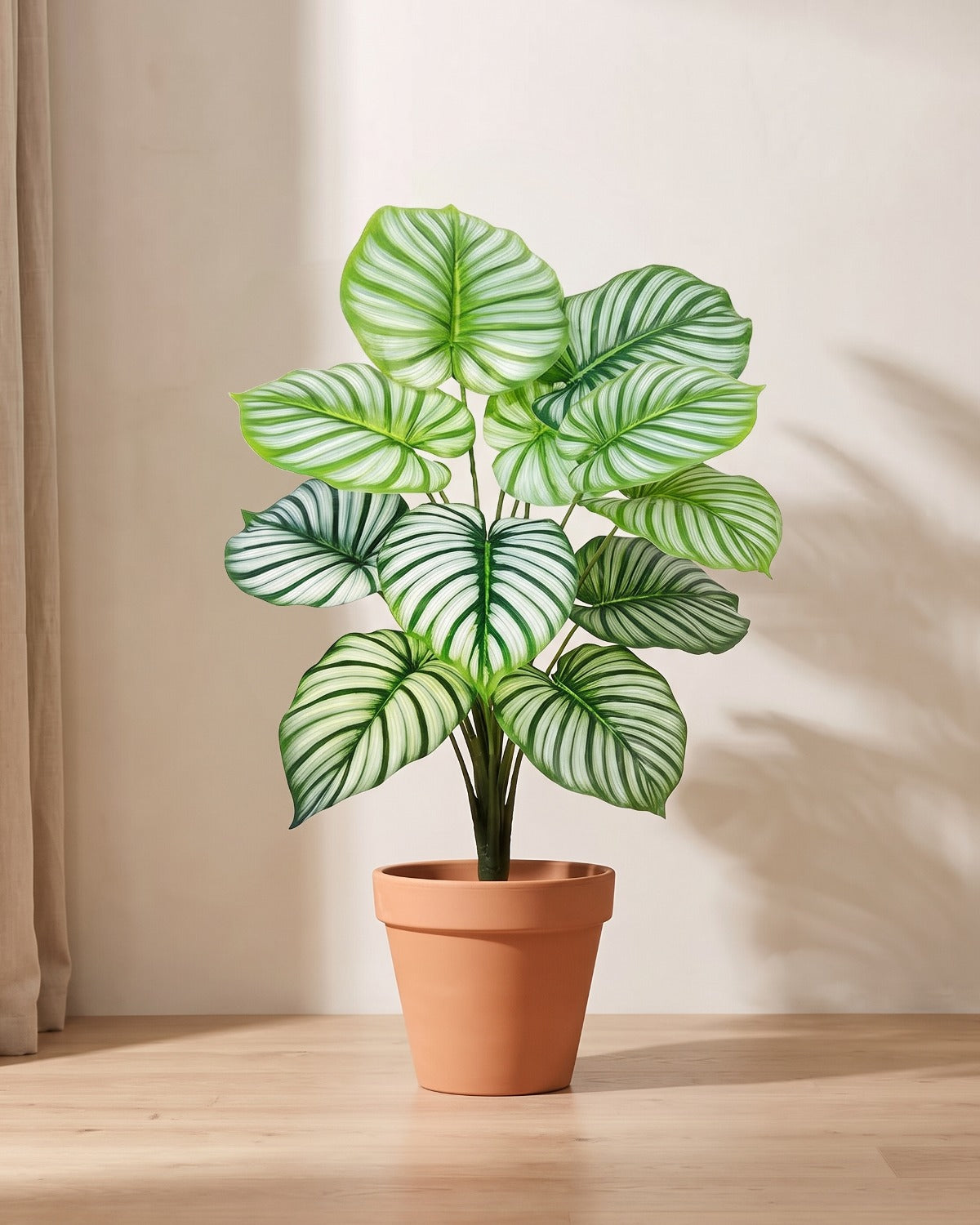 Artificial leaf bush with rounded leaves striped silver-white along every vein, in a plain terracotta pot; pot not included