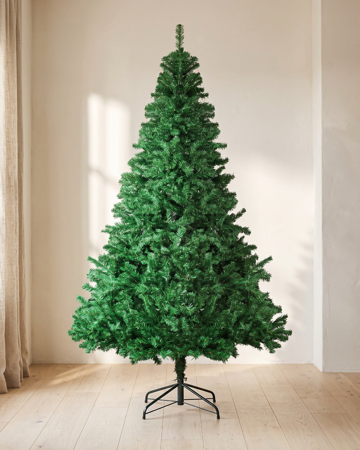 Green artificial spruce Christmas tree, undecorated, on its folding metal stand