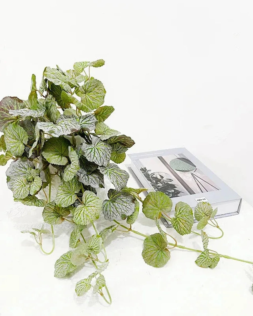 Close view of the artificial begonia vine's speckled round leaves and trailing stems