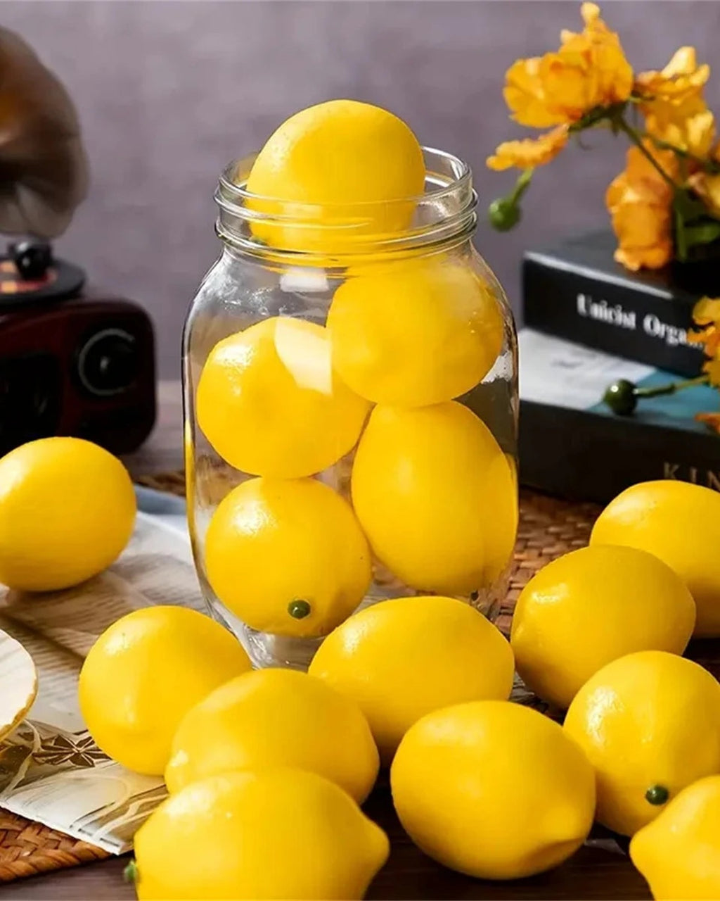 Artificial lemons in a glass jar and scattered on a table