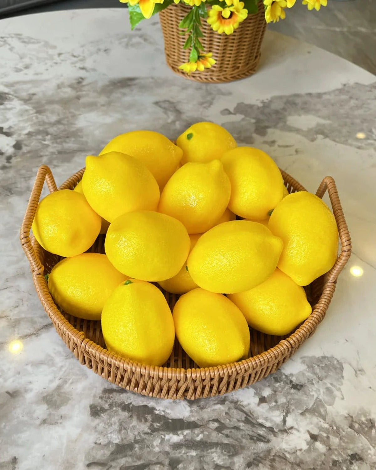 Artificial lemons in a woven basket on a marble counter