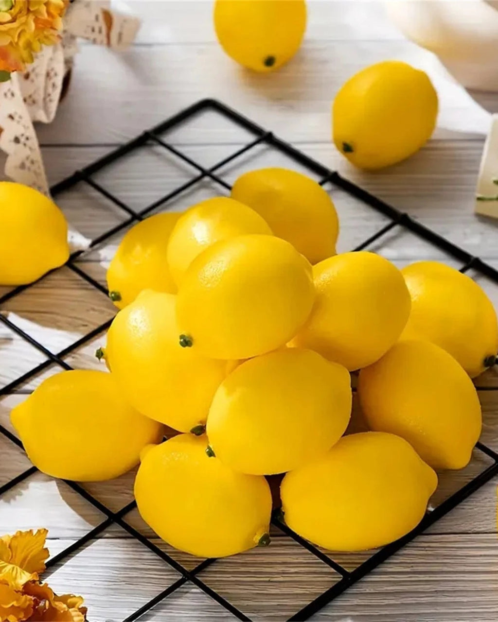 Artificial lemons piled on a black wire tray