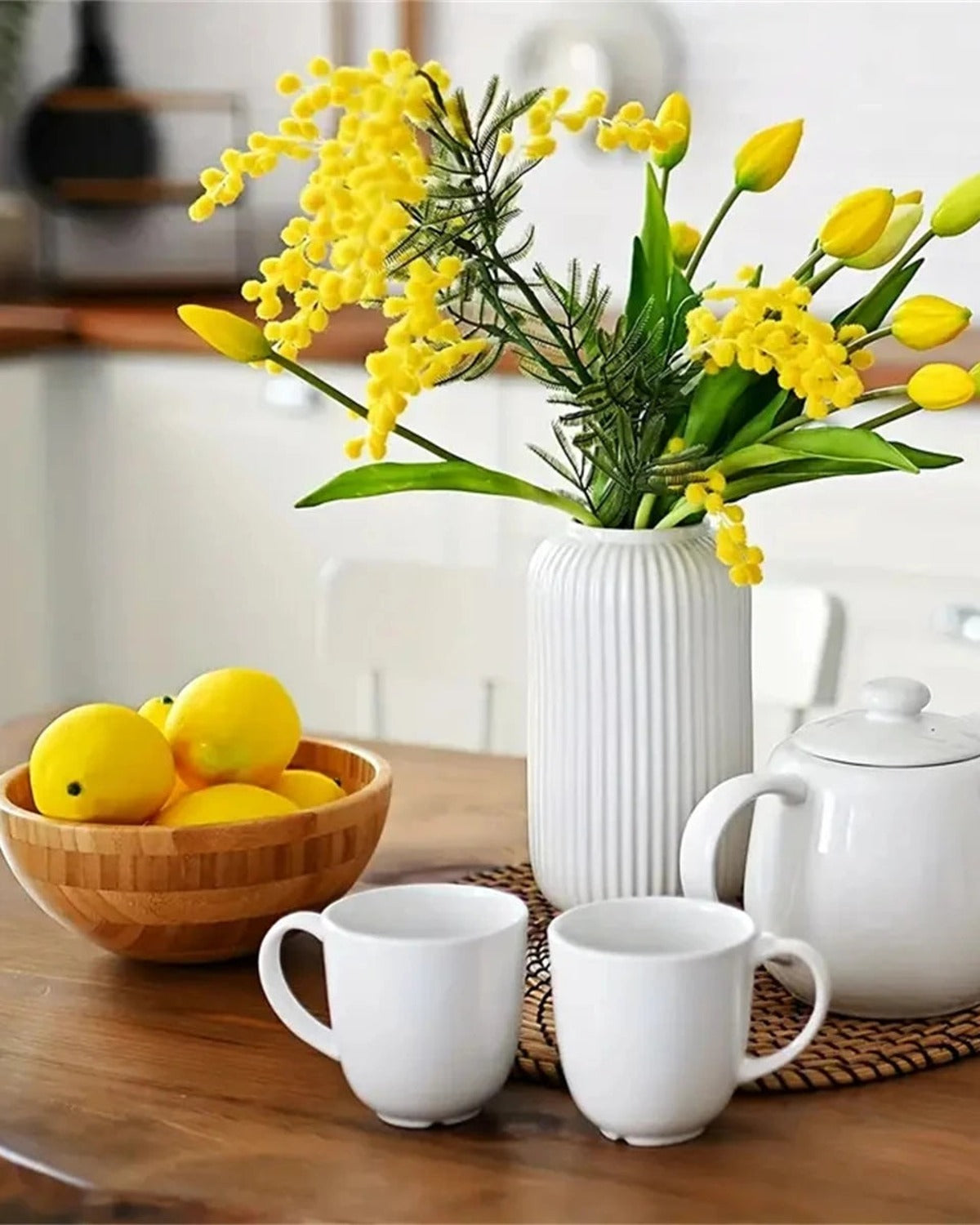 Artificial lemons in a wooden bowl beside a vase of flowers; only the lemons are part of the order