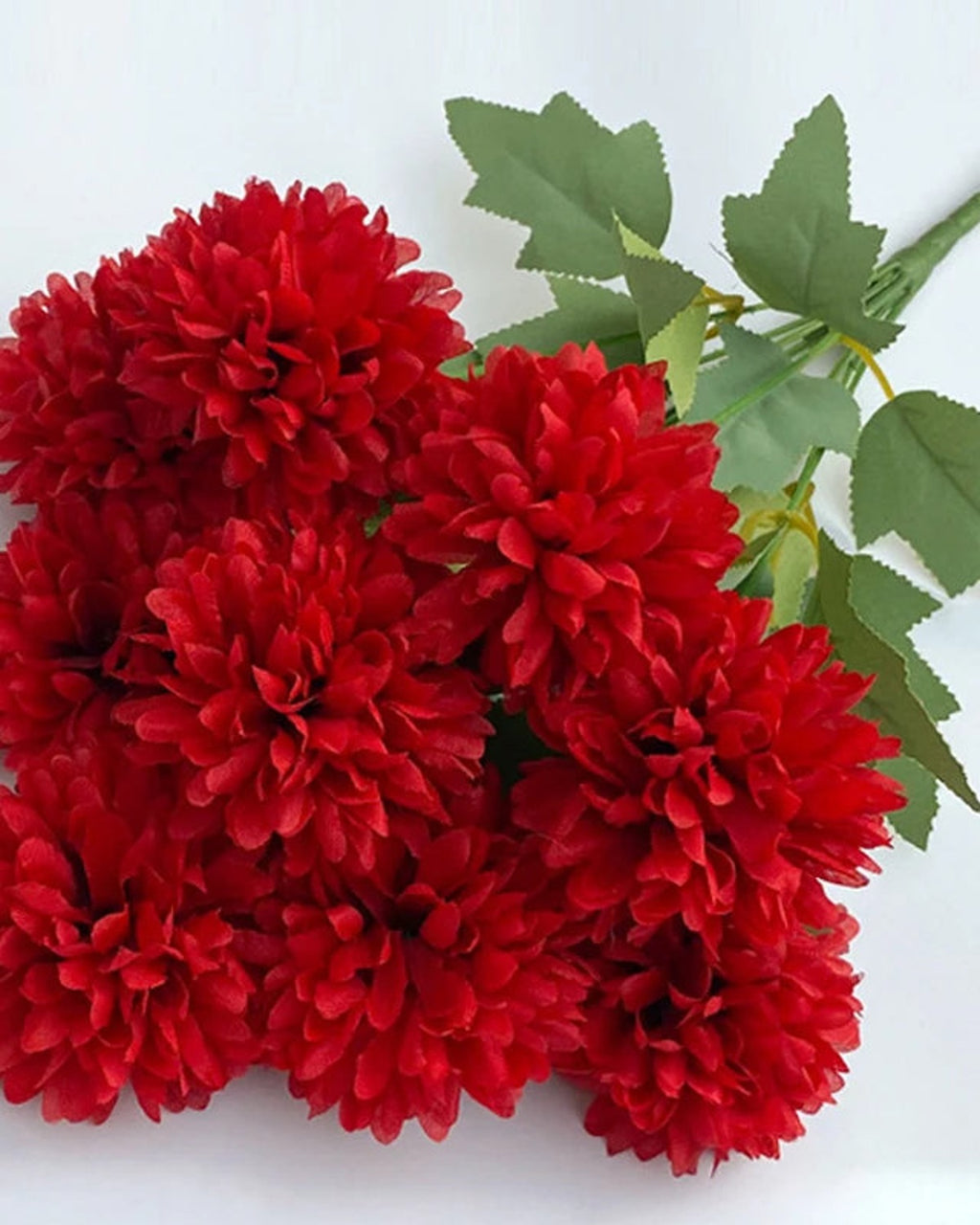 Red artificial pompom chrysanthemums, the ball shaped blooms in close view
