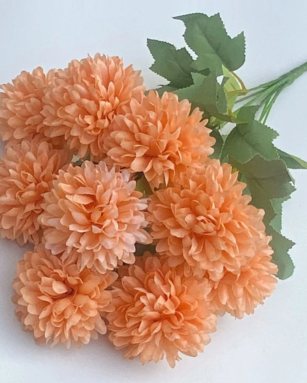 Peach artificial pompom chrysanthemums, the ball shaped blooms in close view