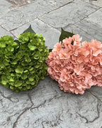 Two artificial hydrangea bunches side by side on paving, green and a paler shade; each order is one bunch