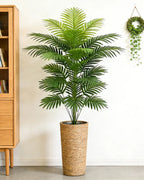 An artificial palm leaf bush beside a wooden cabinet in a hallway; pot not included